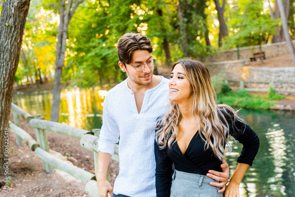 Fototapeta premium Couple of friends flirting fun while hugging on a walk in a natural park.