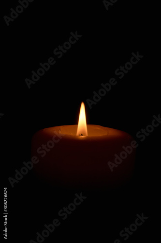 Soft candle light in total darkness with copy space