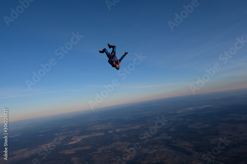 Skydiving. A solo skydiver is in the sunset sky. © Sky Antonio