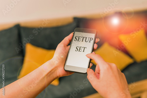 Word writing text Setup Set. Business photo showcasing the analysisner, position, or direction in which something is set woman using smartphone office supplies technological devices inside home photo