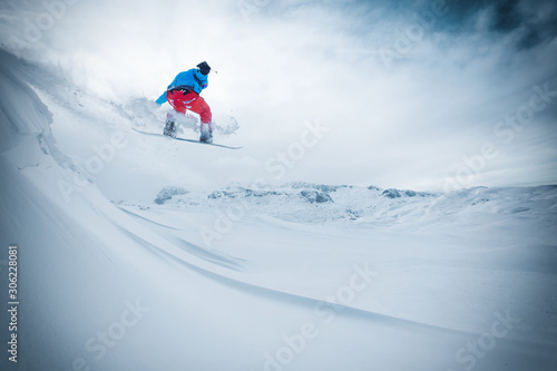 Snowboarder jumping from the rock