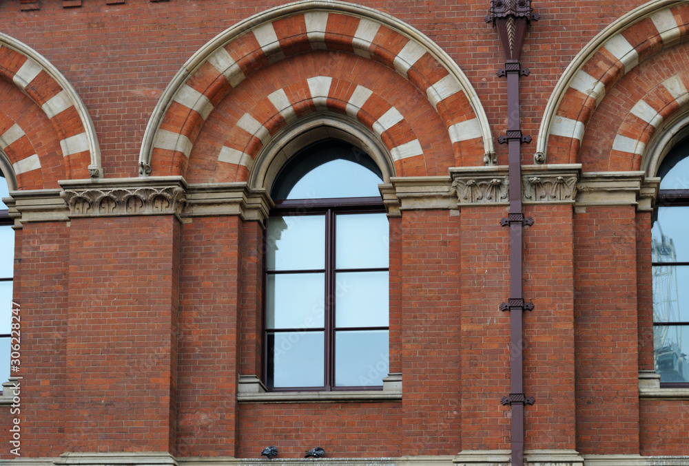 red brick facade of historic building with arched windows red brick facade of historic building with arched windows