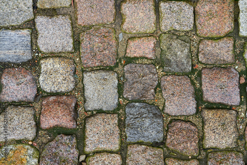 Wet cobbles after rain. A road paved with stone after rain.