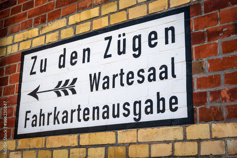 Fototapeta premium Hinweisschild auf Backsteinwand gemalt im Bahnhof, historisch, retro