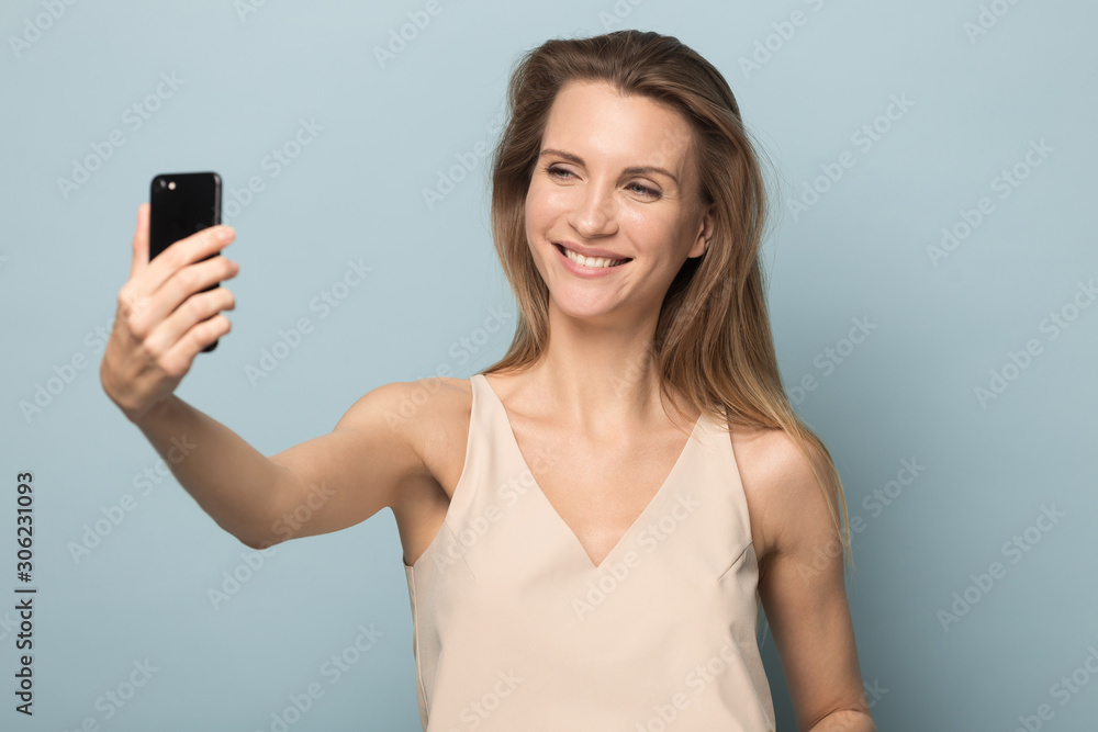 Smiling attractive woman taking selfie, using mobile phone Smiling attractive woman taking selfie, using mobile phone
