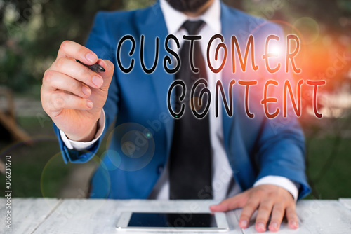 Conceptual hand writing showing Customer Content. Concept meaning content created voluntarily by customers and share publicly Businessman holds pen and points into copy space