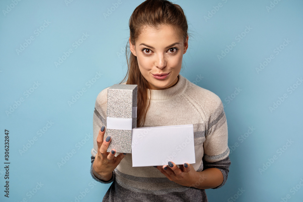 The brunette opens the gift box and looks slyly into the frame. The brunette opens the gift box and looks slyly into the frame.