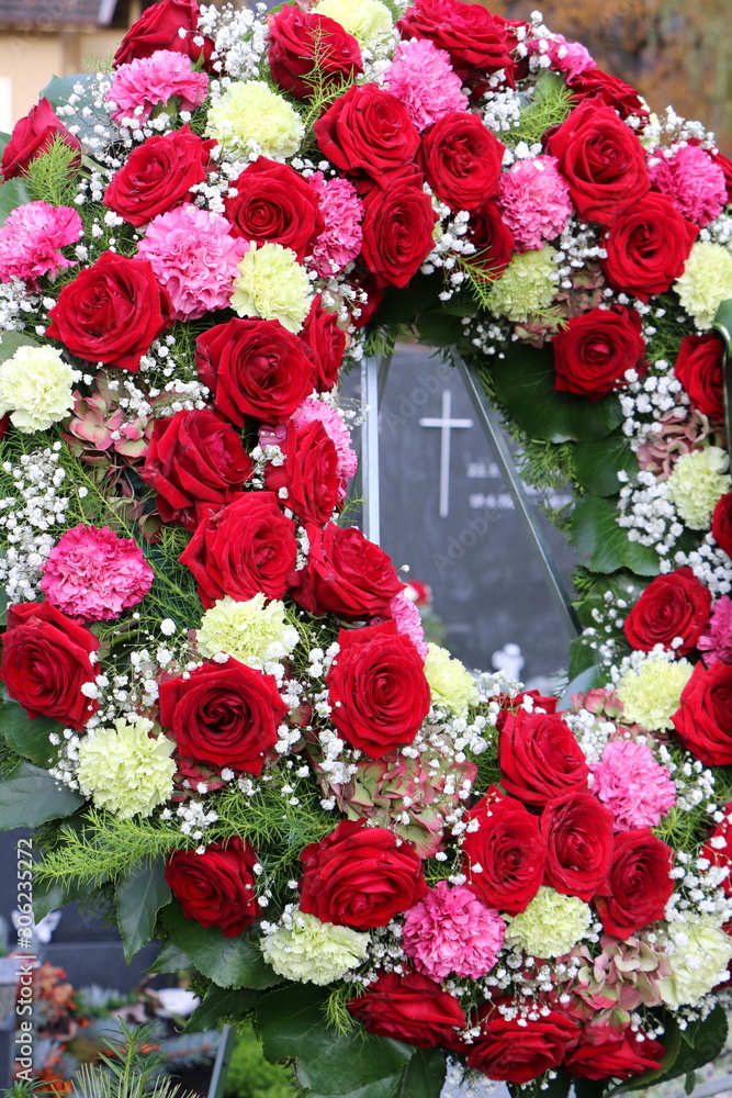 Trauerkranz mit roten Rosen und Nelken an einem neuen Grab, Friedhof in  Österreich, Floristik Stock-Foto | Adobe Stock