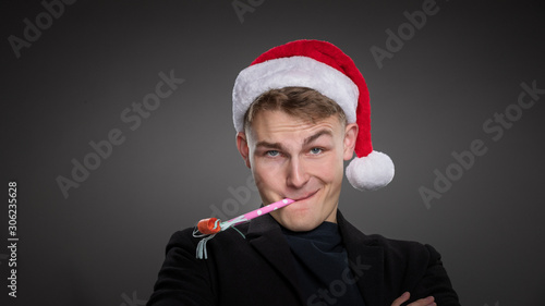 Photography A handsome executive enjoys an office christmas party wearing a red hat & has a