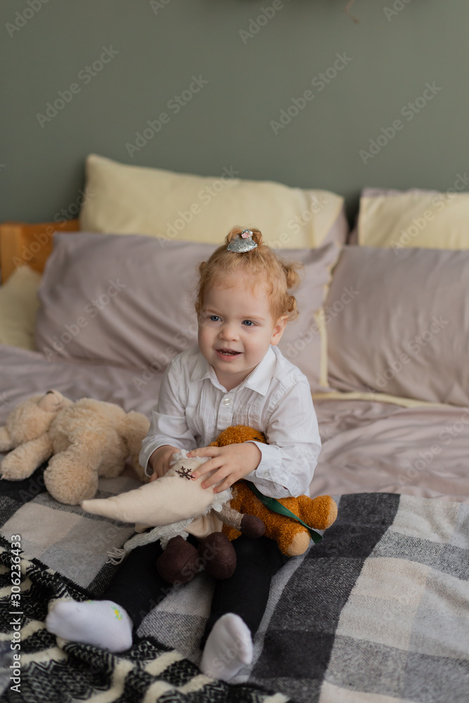 Beautiful little girl on the bed plays with plush toys. Beautiful little girl on the bed plays with plush toys.
