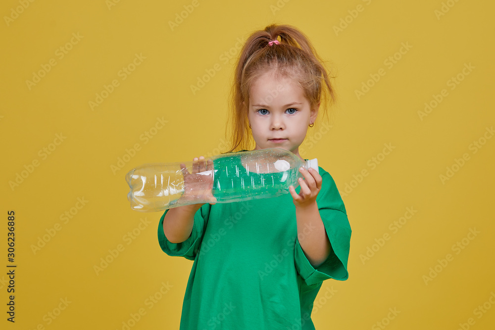 Caring for the environment. Little girl is separate plastic trash to recycle. Bright color studio background Caring for the environment. Little girl is separate plastic trash to recycle. Bright color studio background
