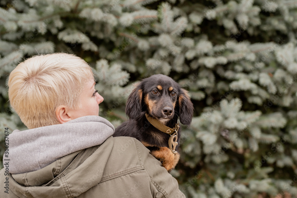 Woman hugging her dog on fir tree background outdoors Woman hugging her dog on fir tree background outdoors