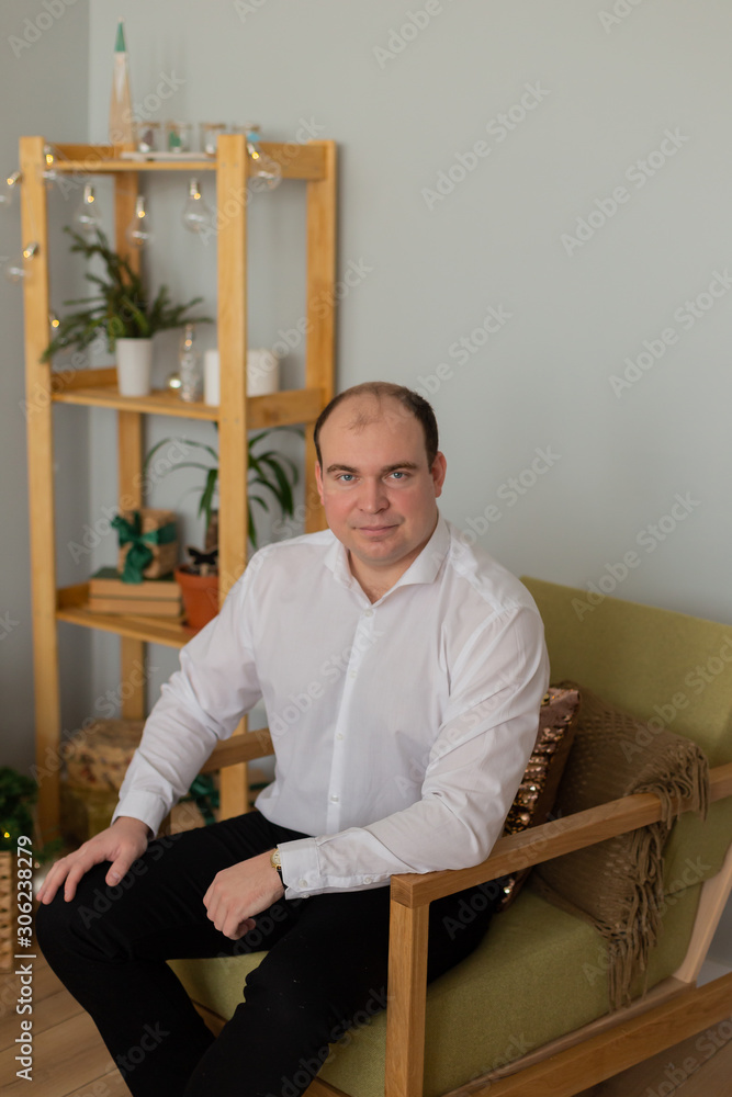 Handsome well-groomed man on a couch in a modern interior. Handsome well-groomed man on a couch in a modern interior.