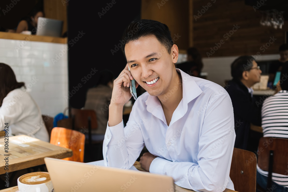 Joyful freelancer sitting in cafe and smiling Joyful freelancer sitting in cafe and smiling