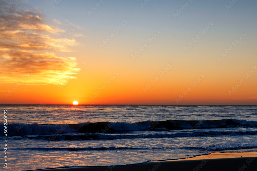 Setting Sun over ocean and beach