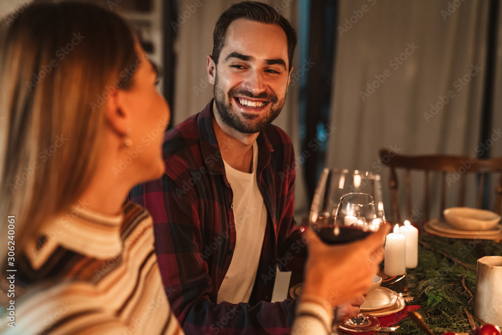 Photo of happy family couple smiling while having Christmas dinner