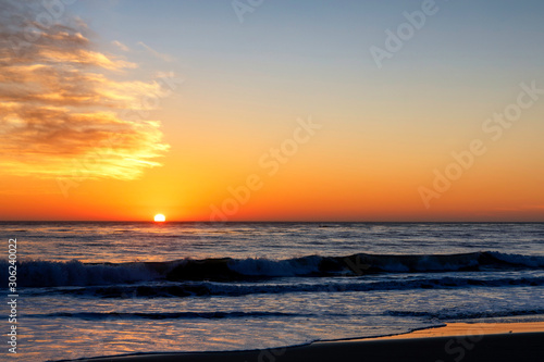 Setting Sun over ocean and beach