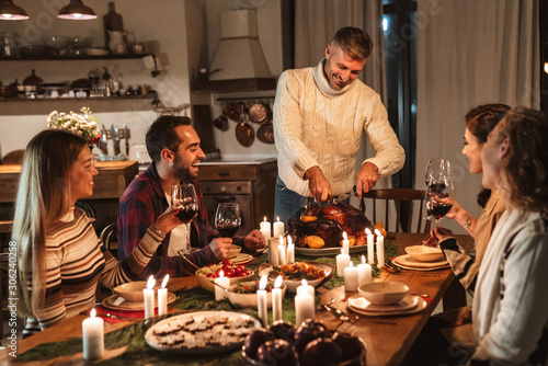 Photo of charming excited people having Christmas dinner with turkey