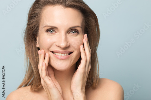 Obraz na plátně Head shot portrait smiling woman touching perfect smooth face skin