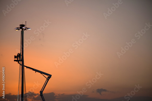 Crane and lighting pole in sunset