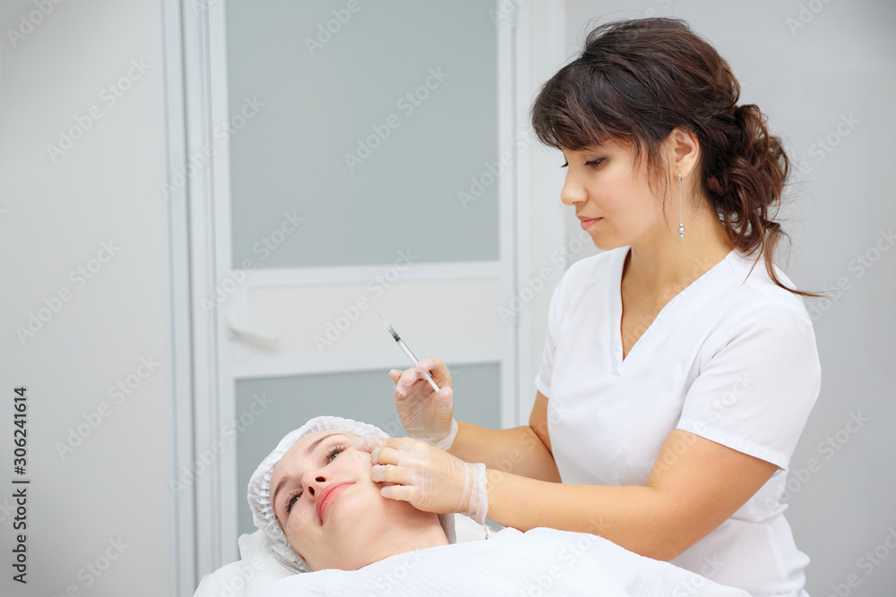 cosmetologist carries out medical procedure with collagen filler to smooth wrinkles on woman forehead cosmetologist carries out medical procedure with collagen filler to smooth wrinkles on woman forehead
