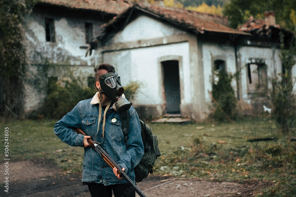 Naklejka premium woman with gas mask, backpack and double barrel shotgun. post-apocalyptic, military and airsoft war games concept.