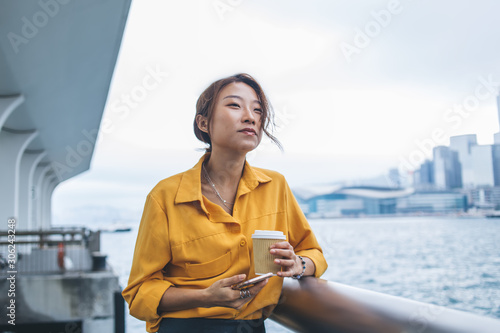 Photography Thoughtful Asian young woman looking at sea at windy day