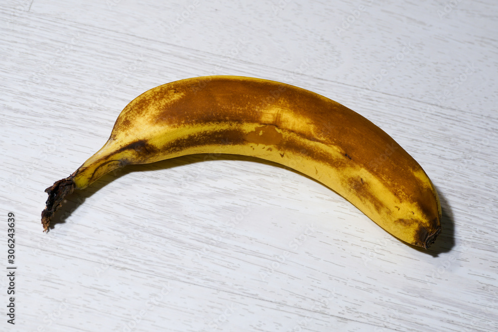 Ripe banana on a white wooden background close-up