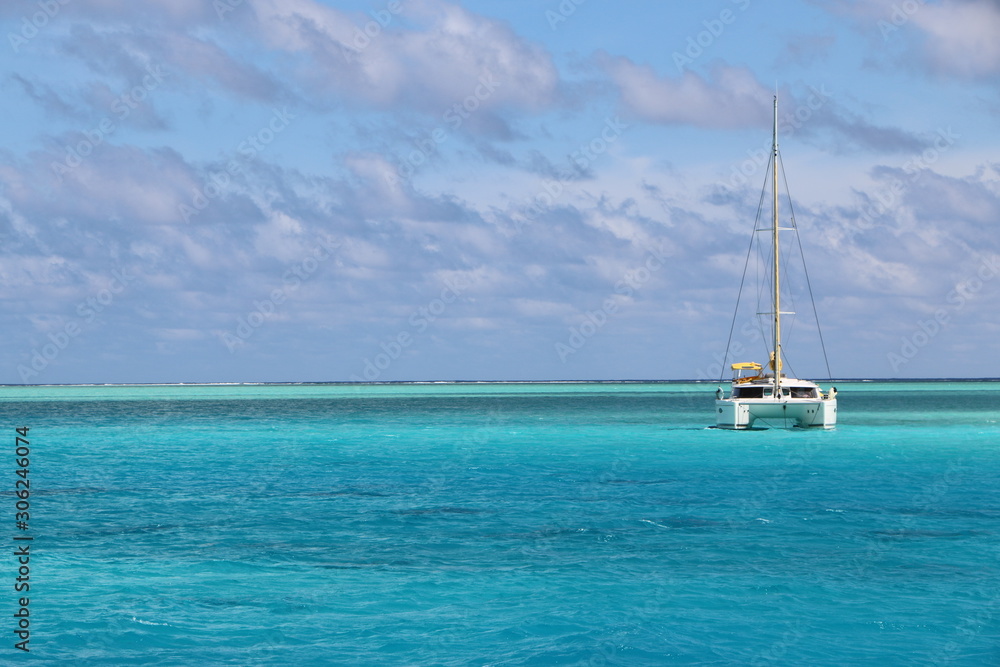 Catamaran at anchor in the blue green lagoon waters of Bora Bora in Tahiti