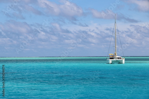 Catamaran at anchor in the blue green lagoon waters of Bora Bora in Tahiti
