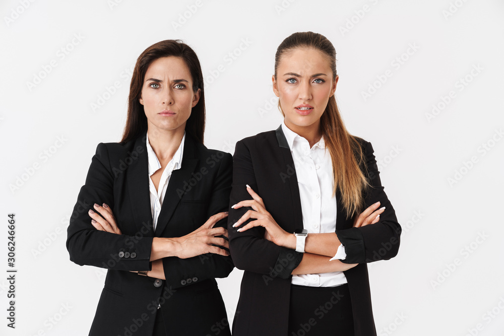 Photo of displeased businesswomen looking at camera with arms crossed Photo of displeased businesswomen looking at camera with arms crossed