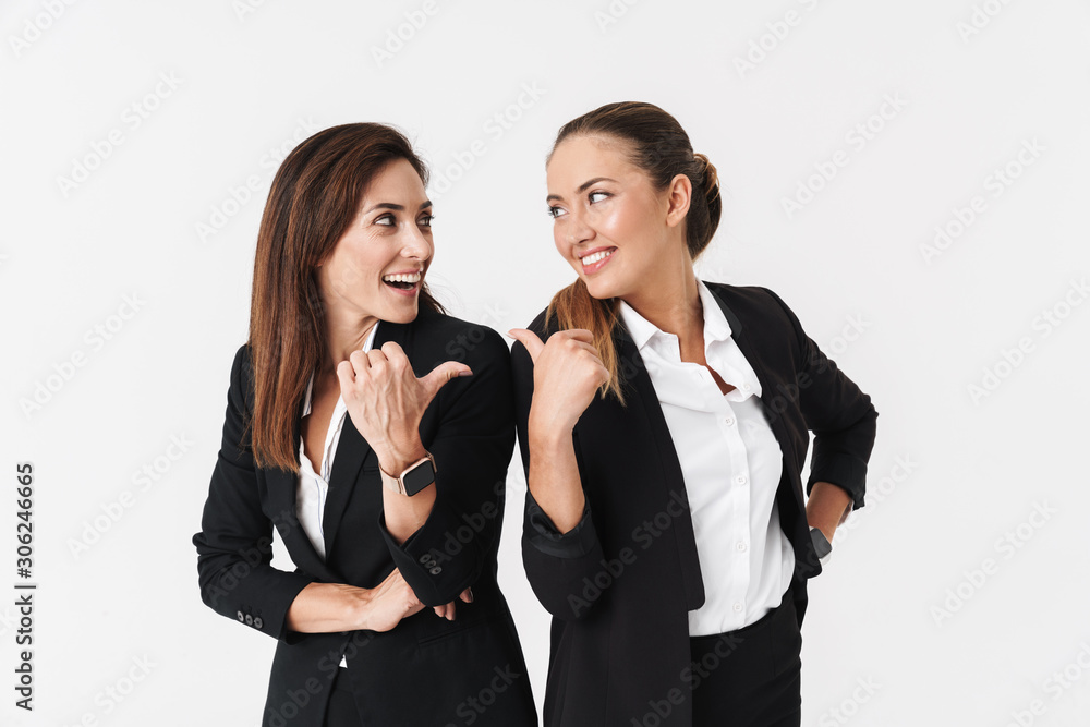 Photo of businesswomen smiling and pointing thumbs at each other Photo of businesswomen smiling and pointing thumbs at each other