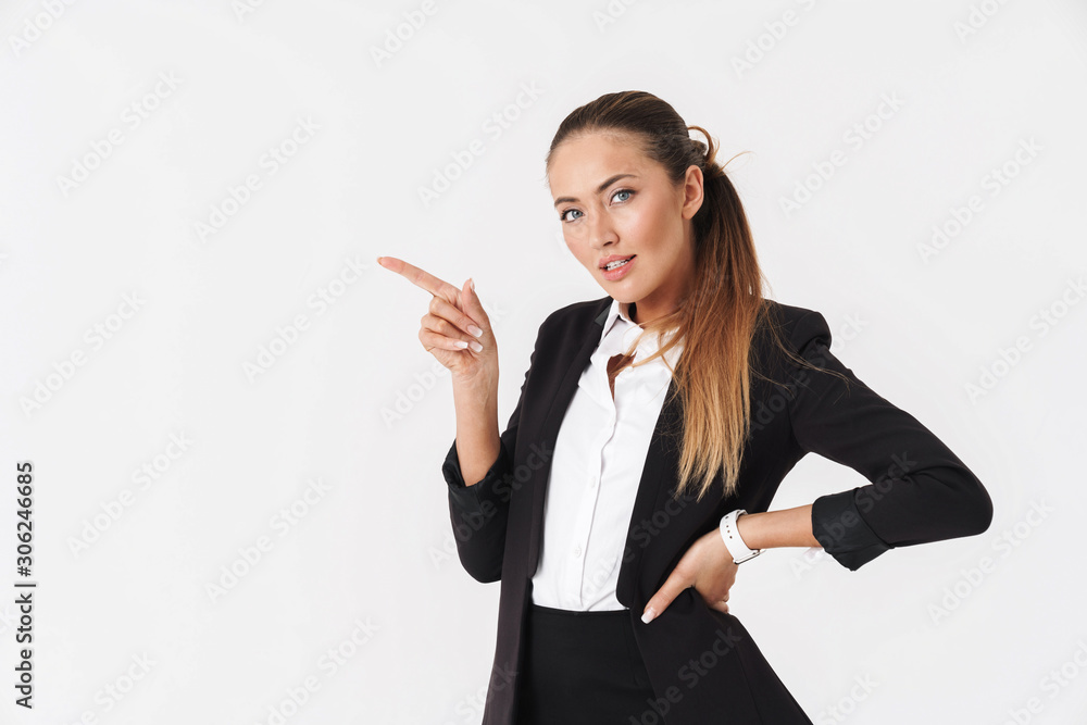 Photo of businesswoman looking at camera and pointing finger aside Photo of businesswoman looking at camera and pointing finger aside