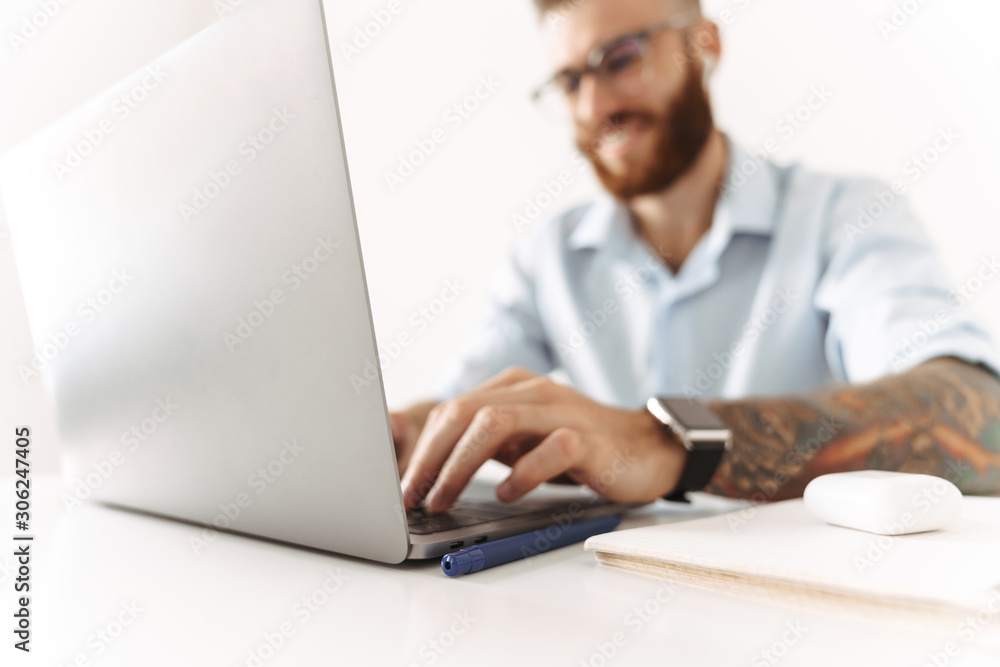 Cheery optimistic young businessman using laptop computer Cheery optimistic young businessman using laptop computer