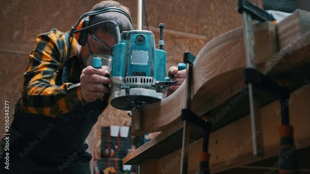 Carpentry industry - a woodworker polishes the wooden detail - sawdust falling down from the detail Carpentry industry - a woodworker polishes the wooden detail - sawdust falling down from the detail