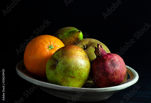 VARIOUS AUTUMN FRUIT ON PORCELAIN PLATE AND DARK FUND