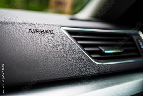 3-D Engraved Airbag Symbol Lettering Bottom Frame Left in Grainy Textured Black Dashboard with Air conditioning system. Interior details.