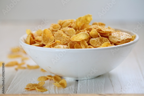Cornflakes with milk in a plate on the table