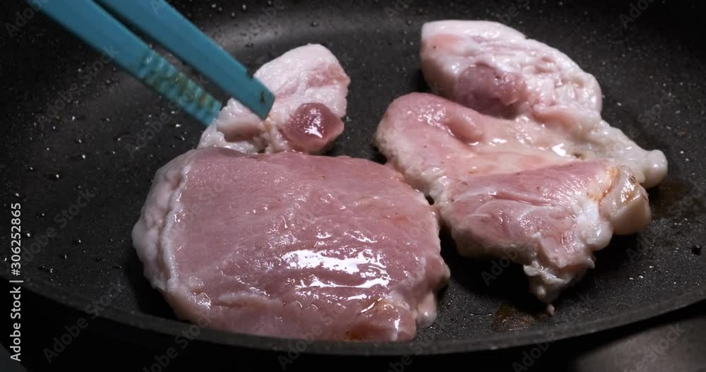 At home, in hot pan, they cook meat, roast pork, raw meat, hearty breakfast, hot pan, tongs turn over meat chunks, beef, cooking, tasty, unhealthy food, obesity, heart attack, close-up, calories At home, in hot pan, they cook meat, roast pork, raw meat, hearty breakfast, hot pan, tongs turn over meat chunks, beef, cooking, tasty, unhealthy food, obesity, heart attack, close-up, calories