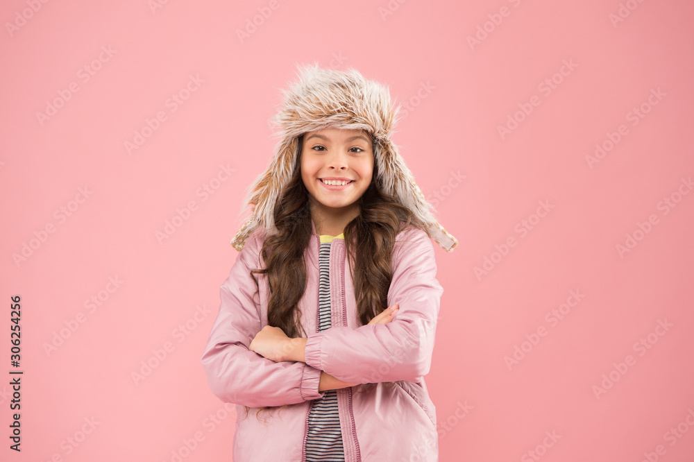 Faux fur trend. Playful kid girl wear fur hat with ear flaps pink background. Soft furry accessory. Child long hair soft fur hat enjoy softness. Winter fashion concept. Warm hat for cold weather Faux fur trend. Playful kid girl wear fur hat with ear flaps pink background. Soft furry accessory. Child long hair soft fur hat enjoy softness. Winter fashion concept. Warm hat for cold weather