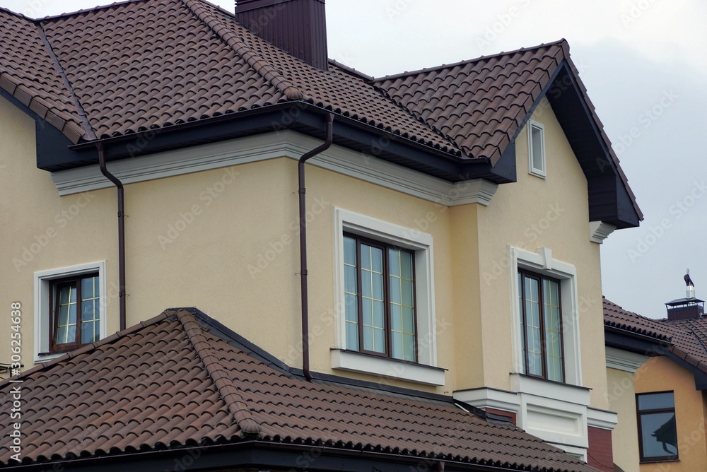 house with windows on a brown wall against a gray sky house with windows on a brown wall against a gray sky