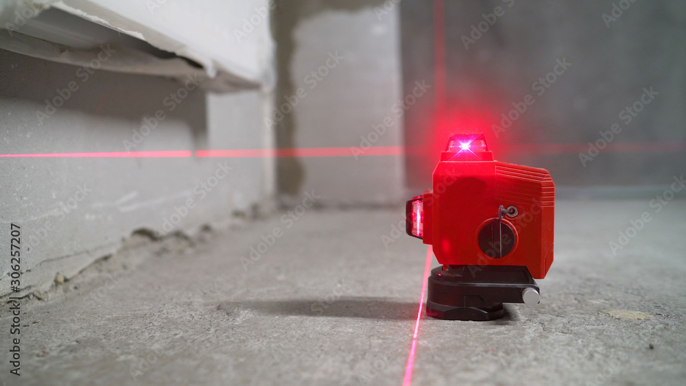 Construction laser level in a building under construction. Laser equipment at a construction site Construction laser level in a building under construction. Laser equipment at a construction site