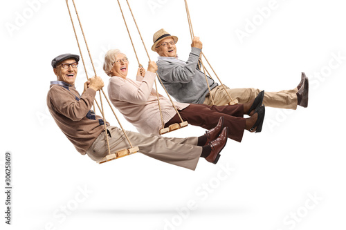 Happy senior people swinging on swings photo