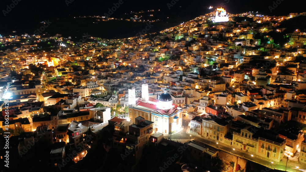 Aerial drone night shot of iconic illuminated church of Agios Nikolaos in famous district of Vaporia in main town of Syros island - Ermoupolis, Cyclades, Greece