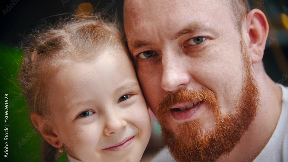 Caucasian family - a dad with ginger beard and daughter smiling Caucasian family - a dad with ginger beard and daughter smiling