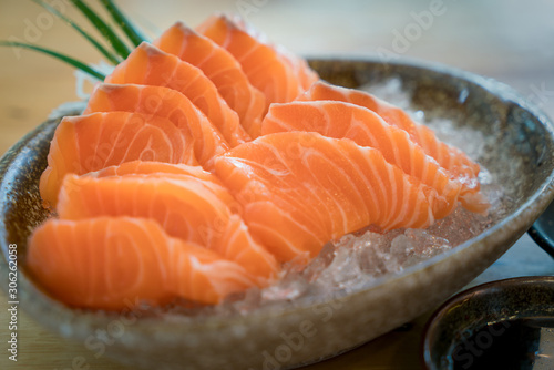 Raw salmon slice or salmon sashimi in Japanese style fresh serve on ice in bowl. Japanese traditional food or with low calories and high nutrition and healthy diet dish.