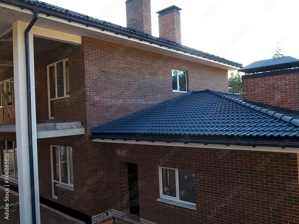 New brick house. House with ceramic tile roof. cement-sand roof New brick house. House with ceramic tile roof. cement-sand roof