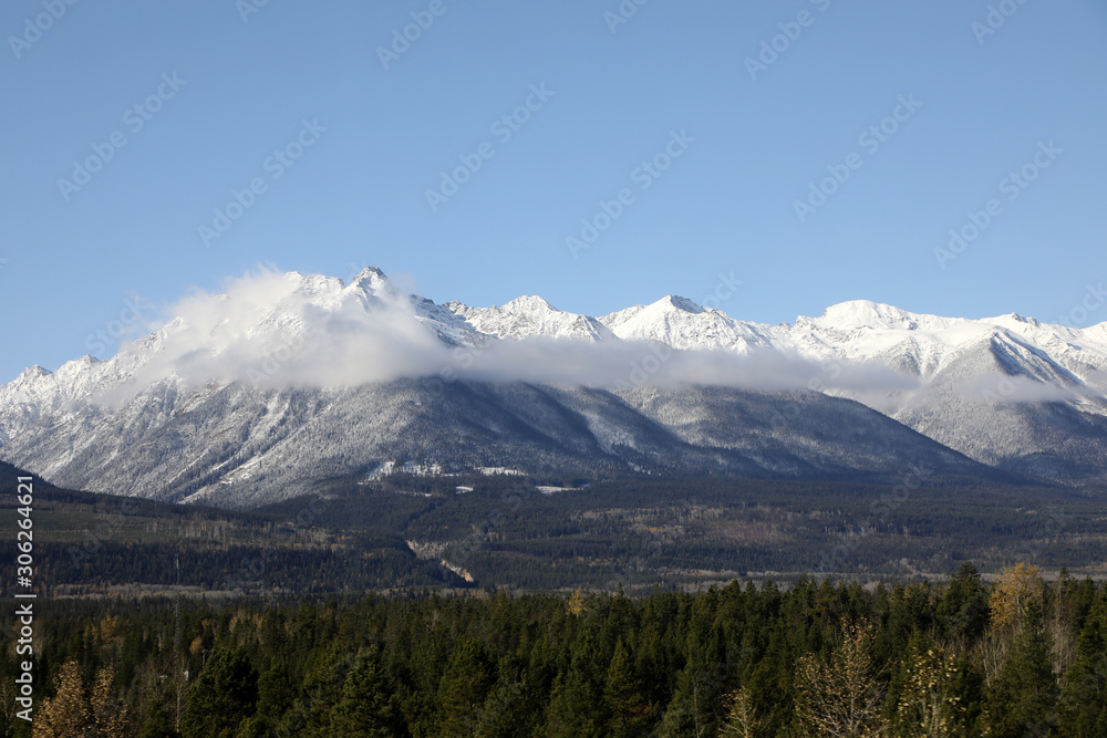 Fototapeta premium The wonderful train journey from Jasper to Vancouver in British Columbia, Canada in Autumn. With train, trees, foliage and snow capped mountains