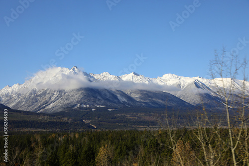 The wonderful train journey from Jasper to Vancouver in British Columbia, Canada in Autumn. With train, trees, foliage and snow capped mountains