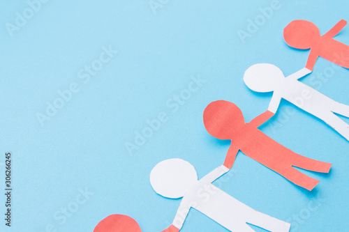 Red and white figures cut out of paper. Blue background